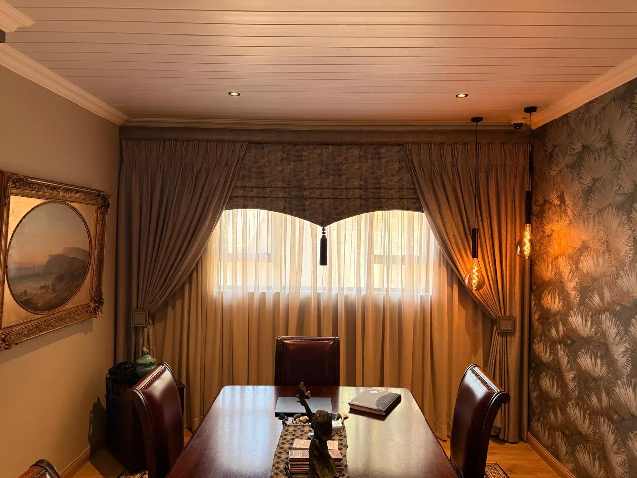 Funeral parlour consultation room with curtains, wallpaper, pendant lighting, chairs and a table