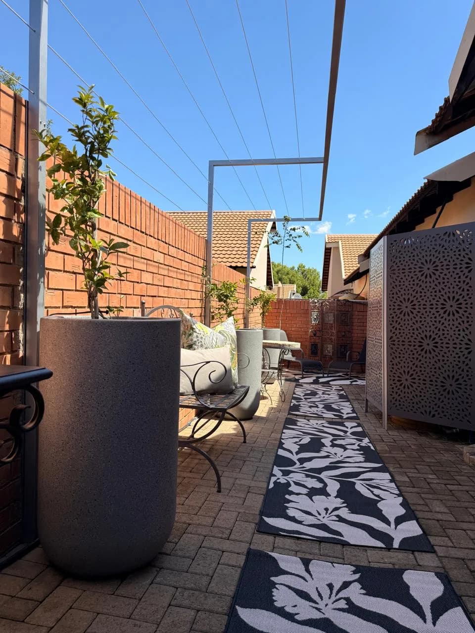 Bloemfontein outdoor area with seating, patterned rugs and large planters