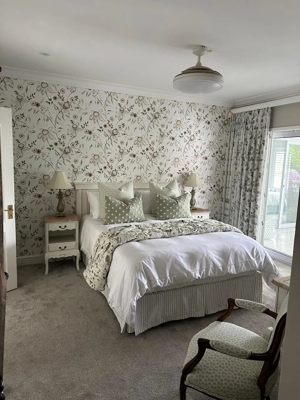 Durban bedroom with floral wallpaper, coordinating curtains and layered bedding