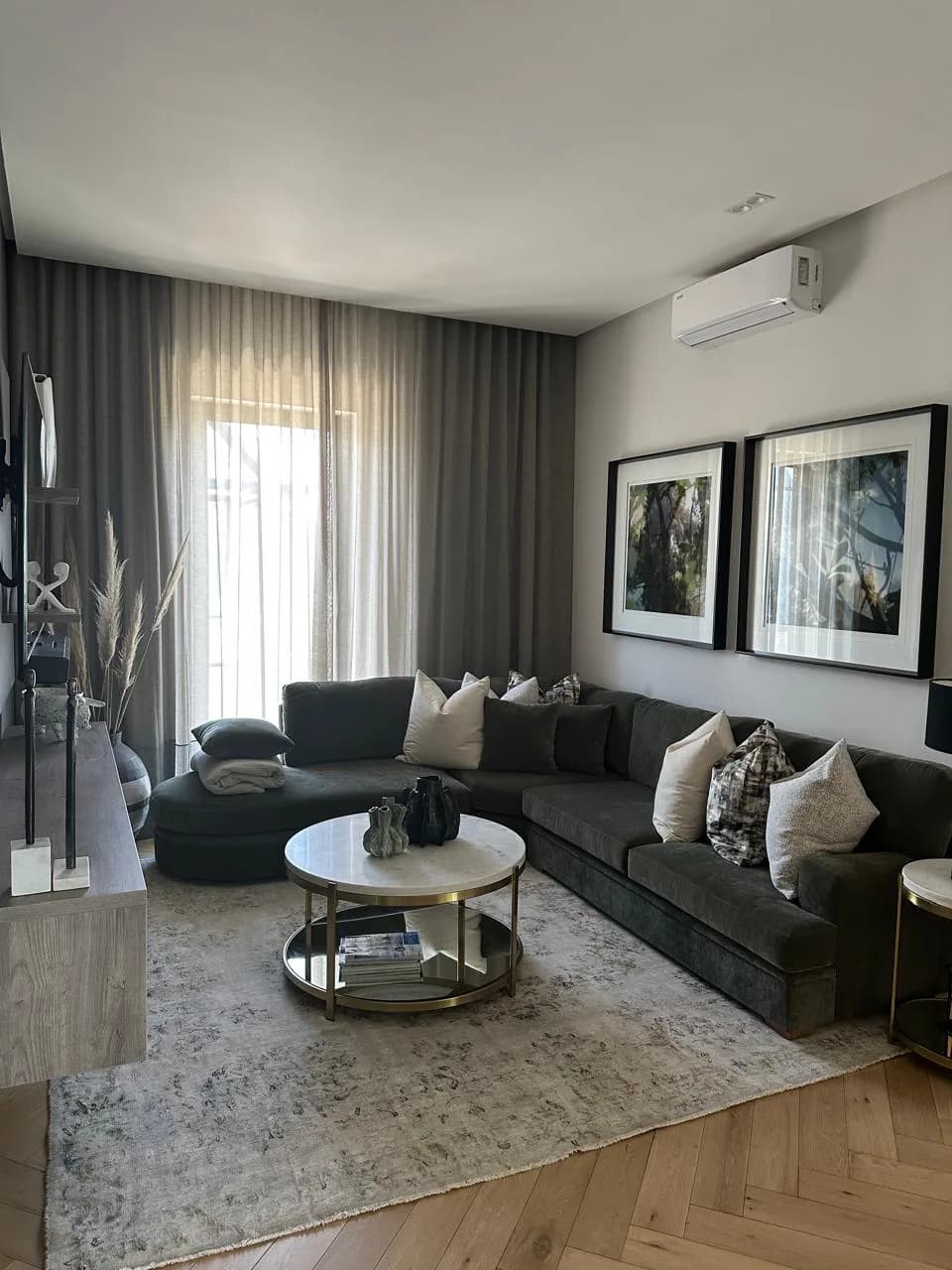 Paarl living room with full-length curtains, a sectional sofa, cushions, rug and round table