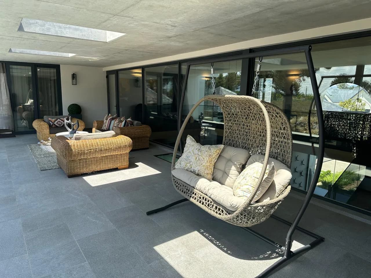 Paarl outdoor lounge with woven furniture, a hanging chair and patterned cushions