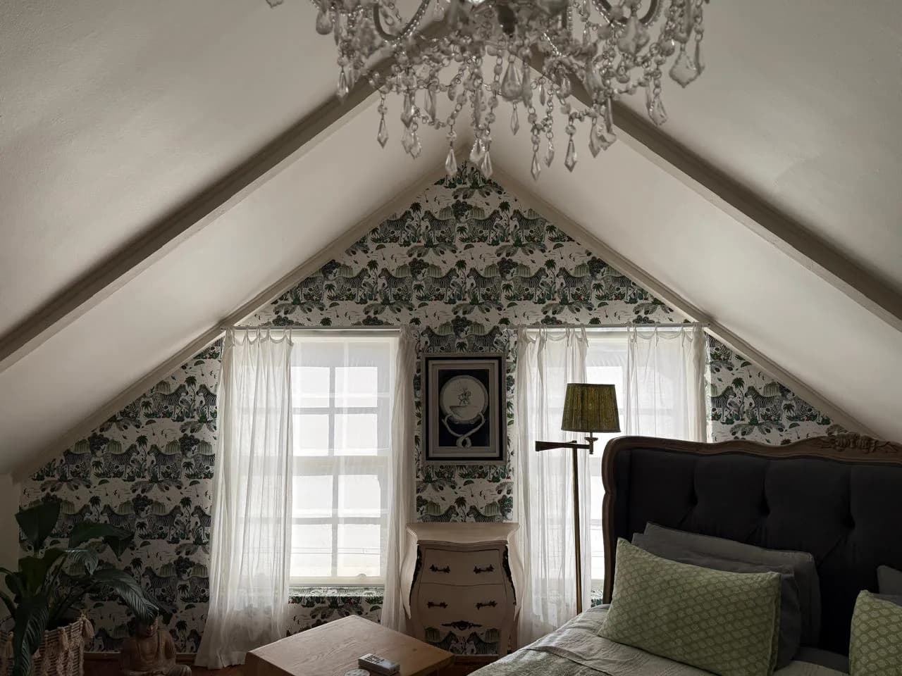 Riebeeck Kasteel attic bedroom with patterned gable wallpaper, sheer curtains, a chandelier and upholstered headboard