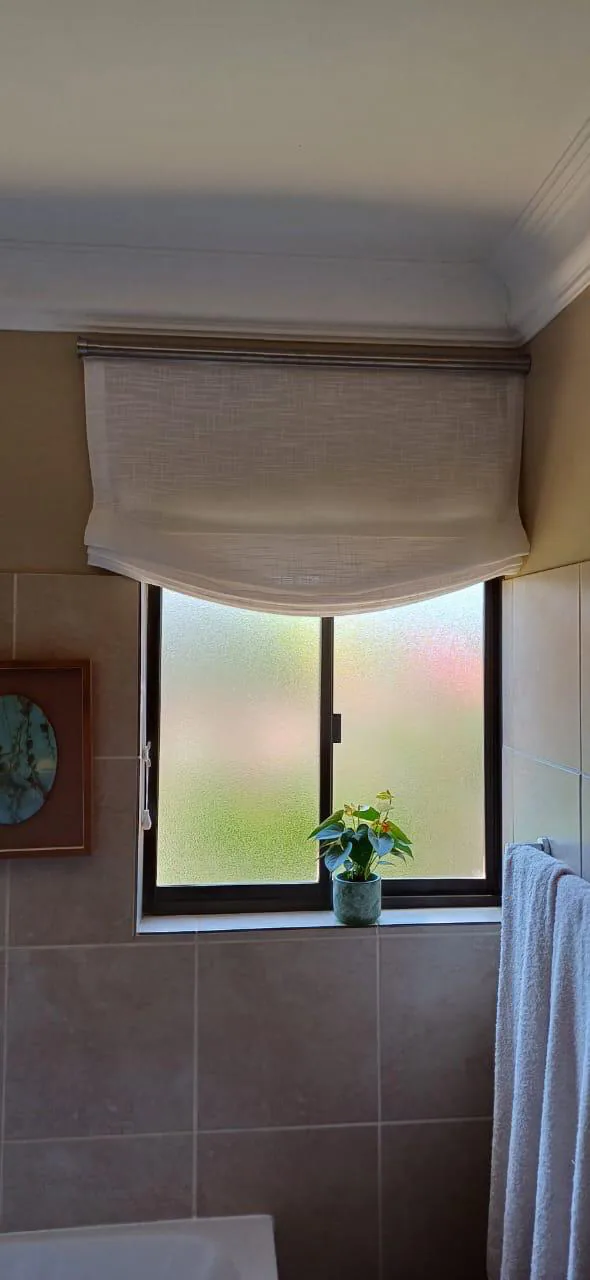 Relaxed Roman blinds: Soft fabric blinds with a relaxed lower fold, suited to bathrooms, bedrooms and spaces that need a softer window finish.