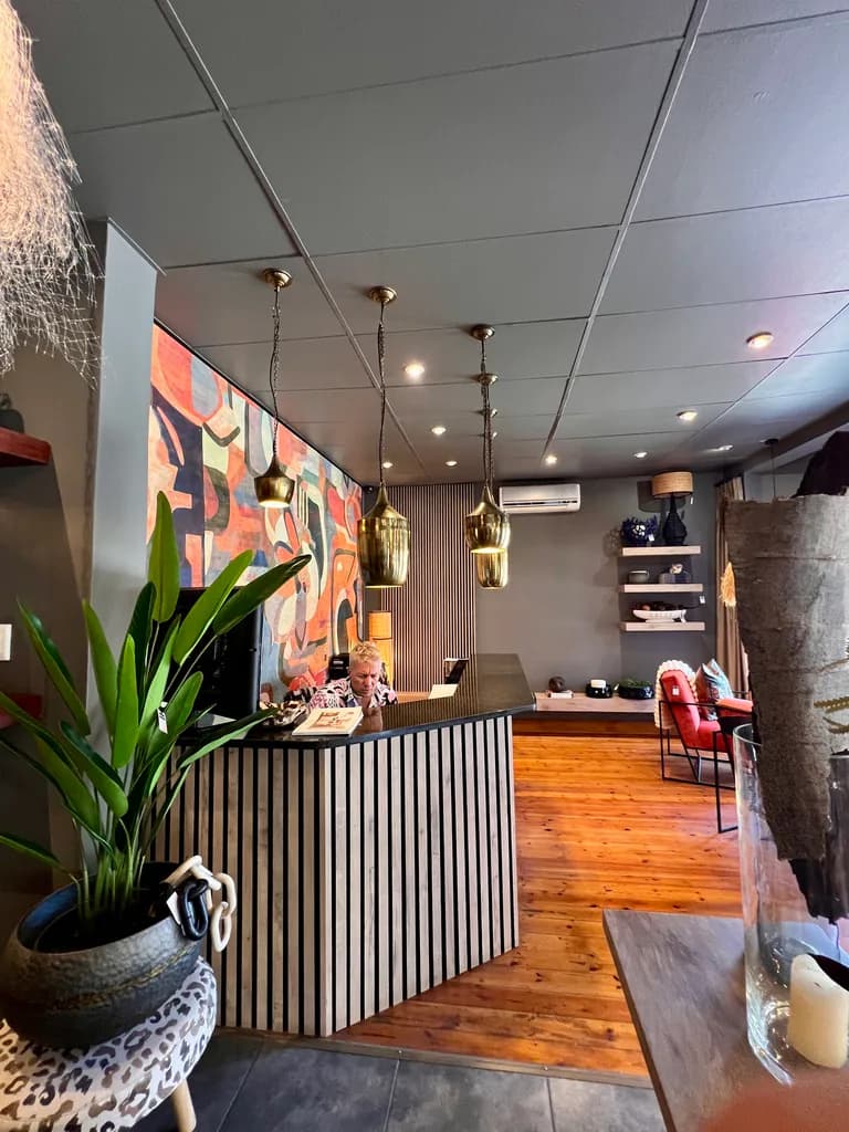 Reception area with plants, pendant lighting and wooden floors.