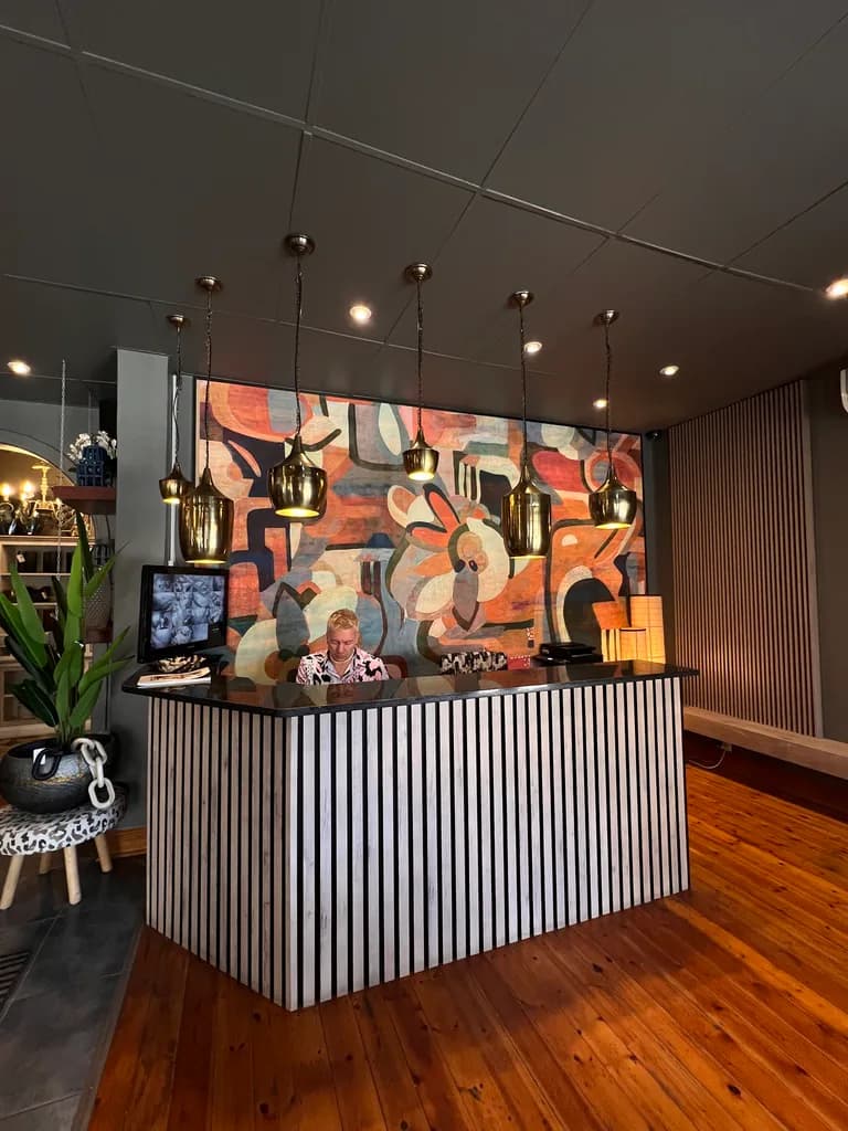 Reception counter with pendant lights and patterned wall finish.
