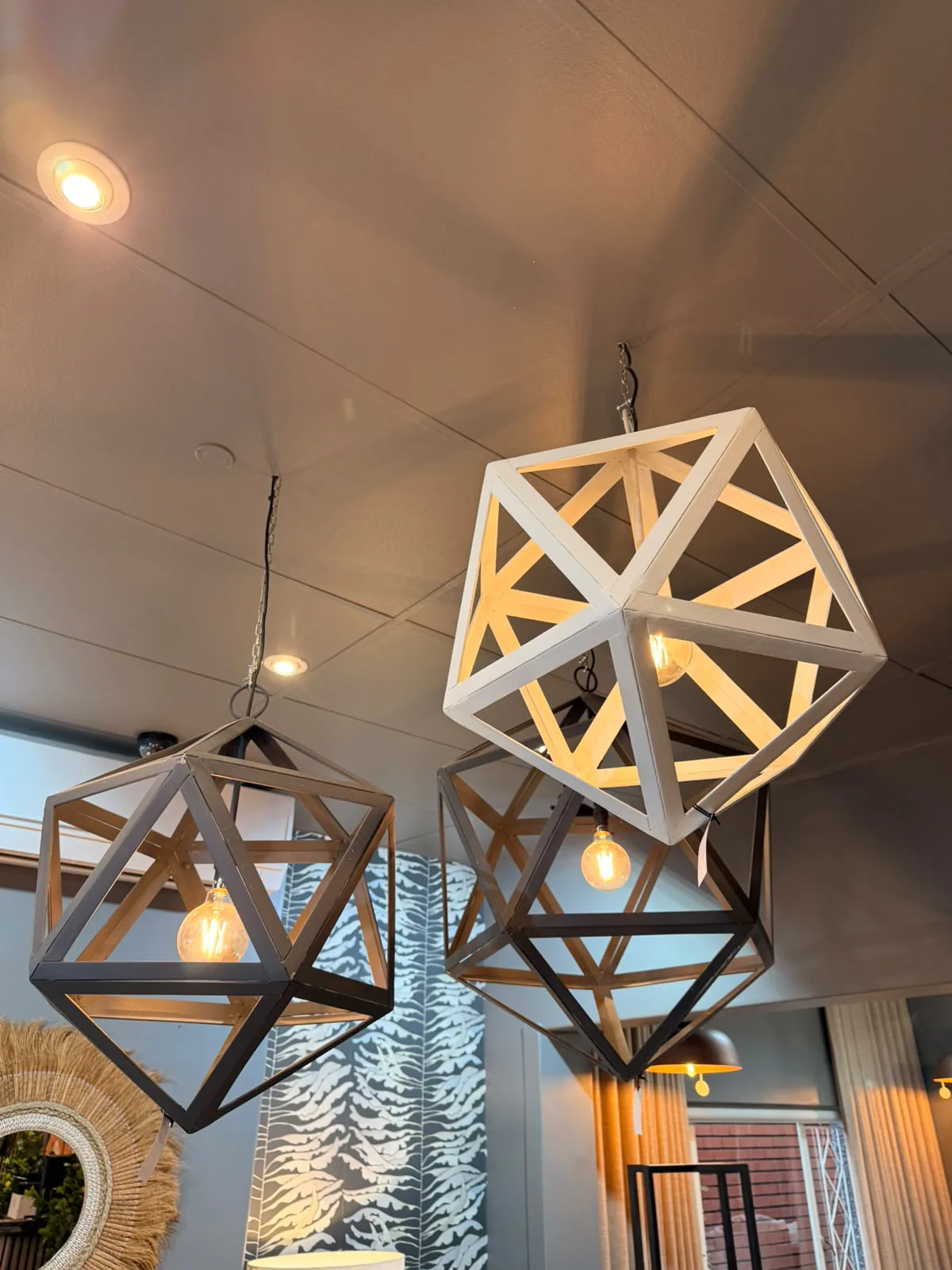Geometric pendant lights illuminated above a showroom display.