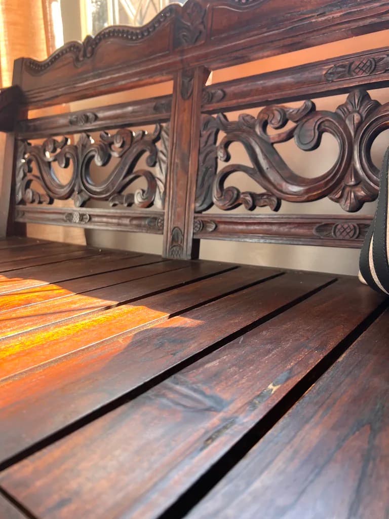 Close-up of a carved wooden bench detail in the showroom.