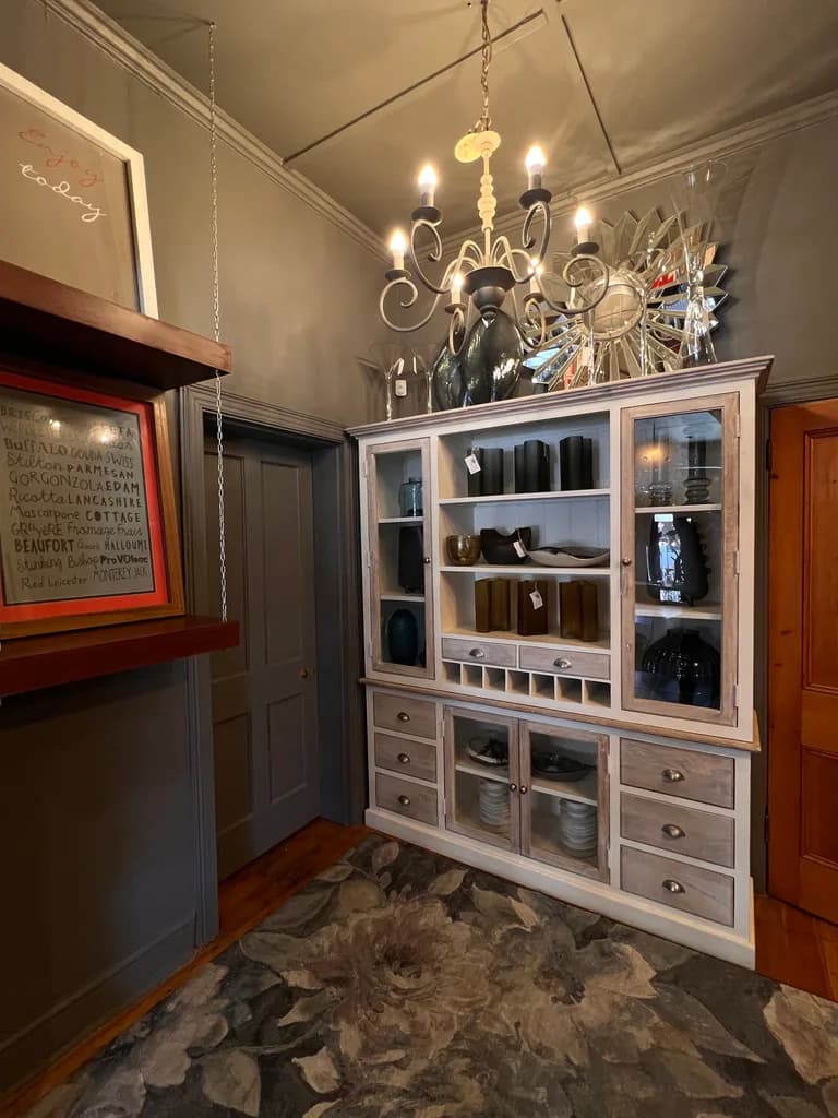 Cabinet, chandelier, mirrors and decor display.