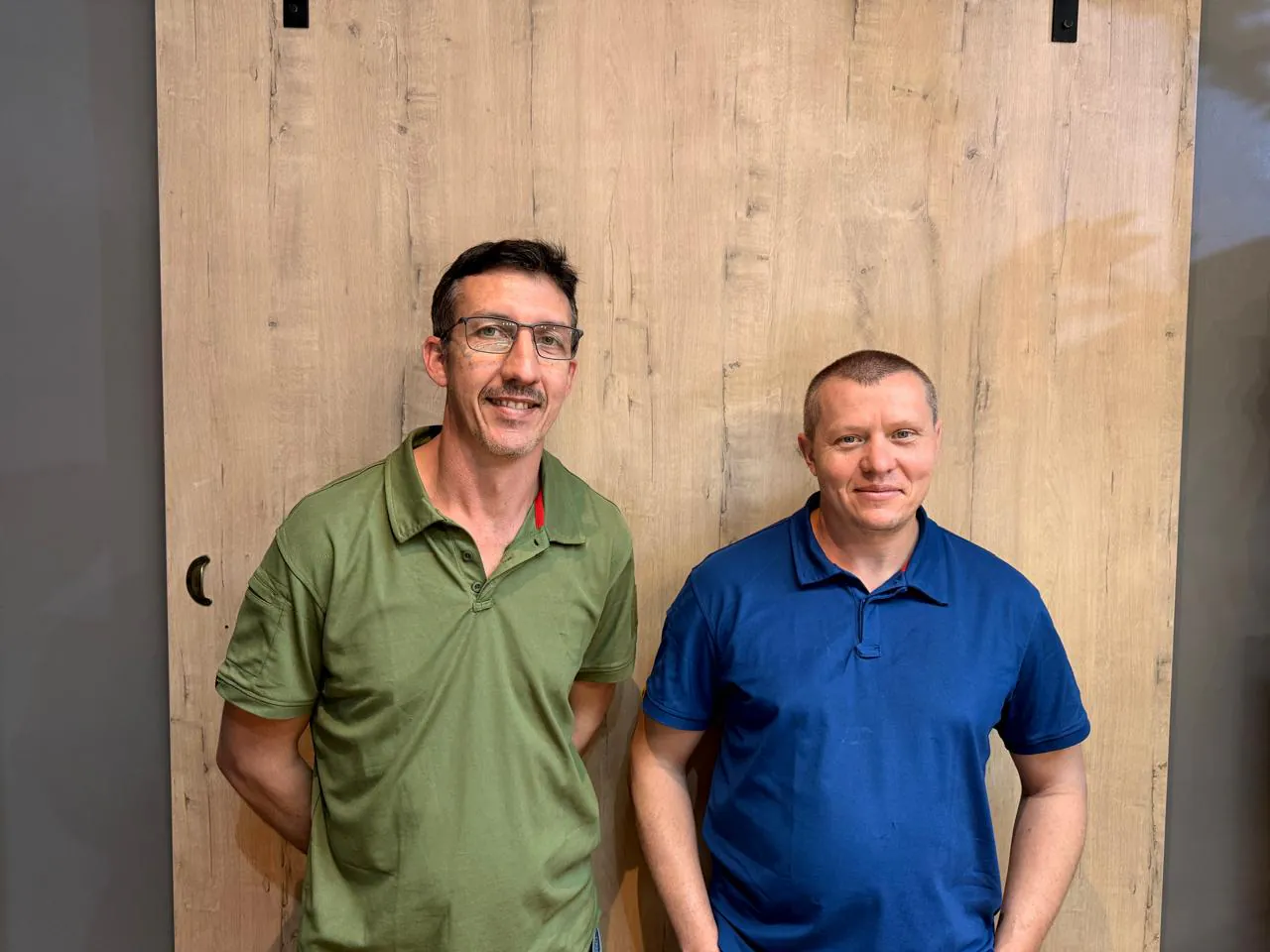 Willie Vermeulen and Anton Beukes standing in front of a wood-panel backdrop