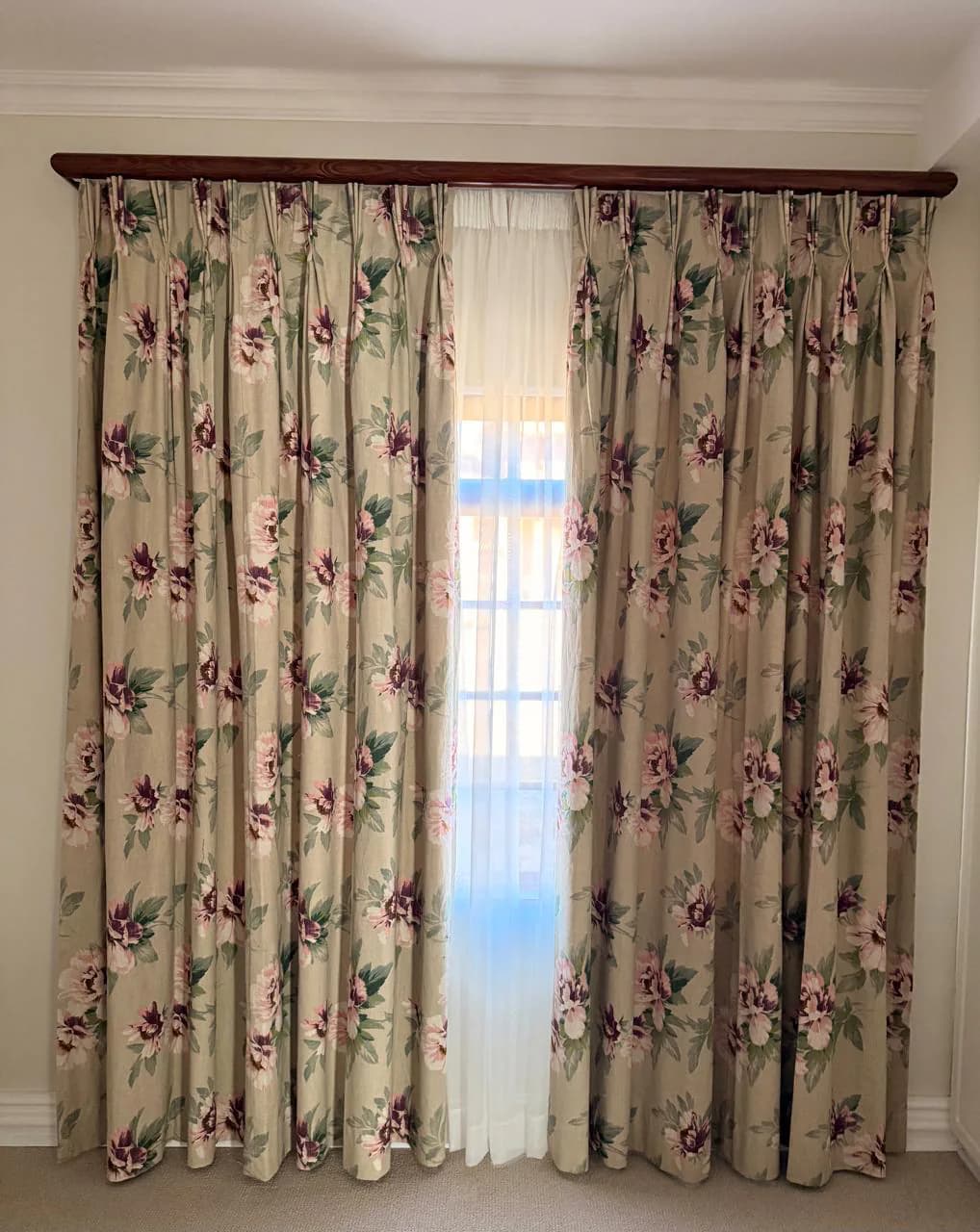 Finished floral curtains hanging in a completed room.